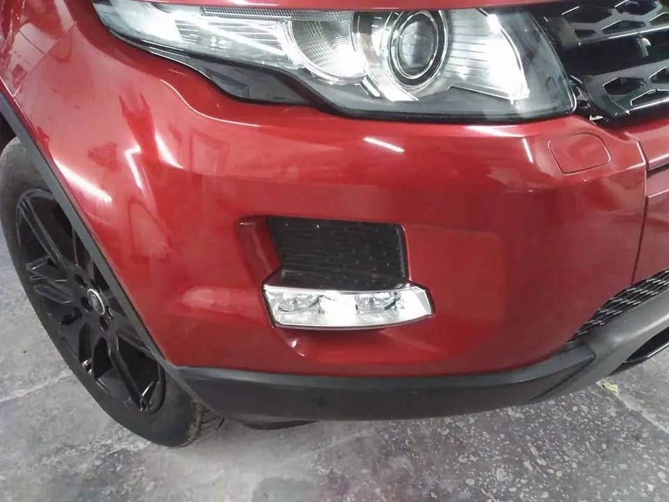 The same corner of the same red car, the bumper smooth and glossy with no marks